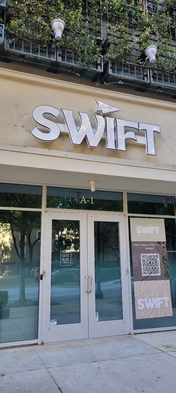 SWIFT channel letters with paper-plane mark over storefront, SWIFT, by High Stakes Creative