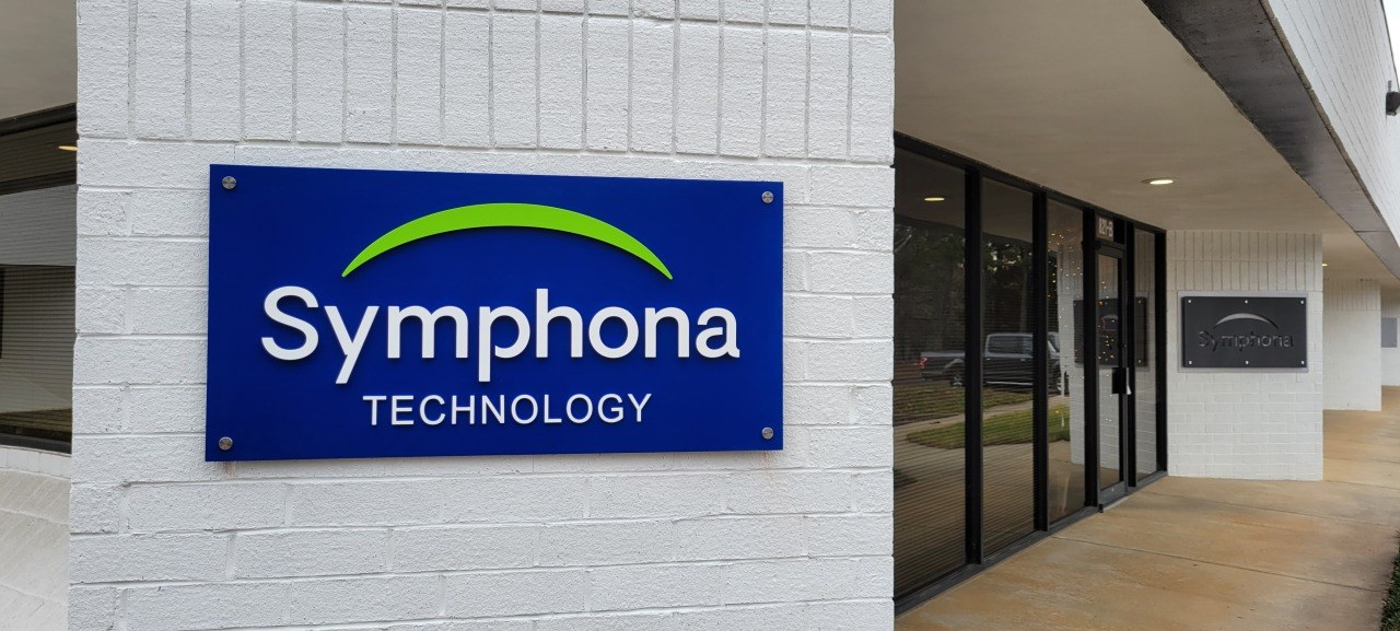 Exterior Symphona Technology panel on white brick by entrance, Symphona Technology, by High Stakes Creative