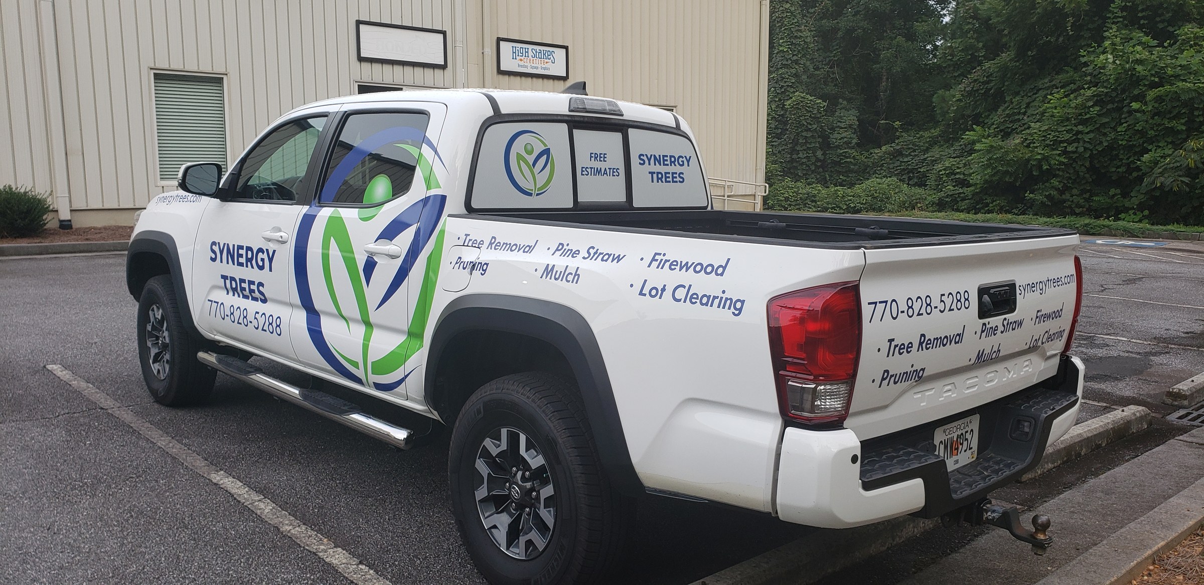 Rear three-quarter of Tacoma with tailgate lettering, Synergy Trees, by High Stakes Creative