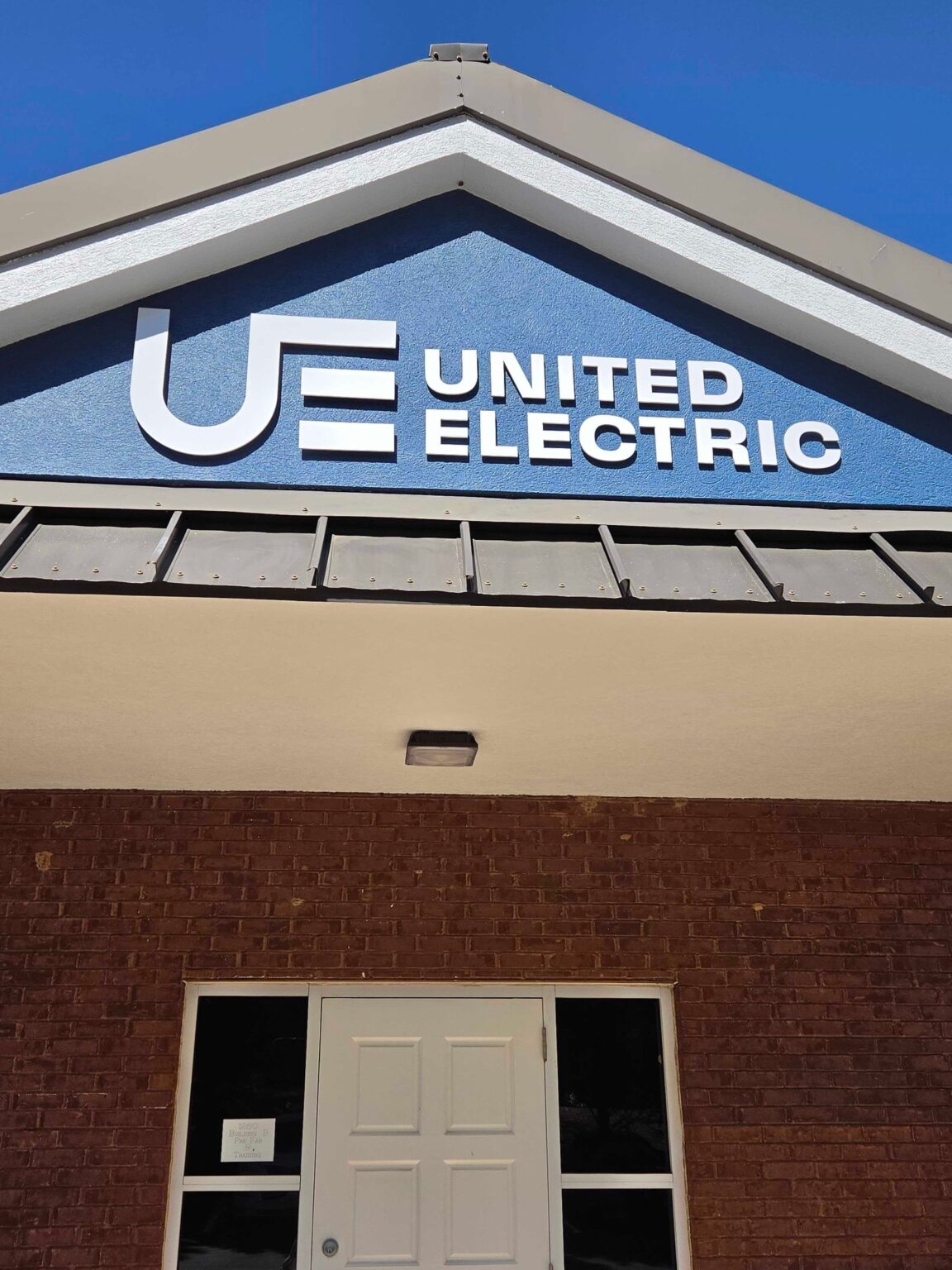 Building logo sign on entry gable, United Electric, Marietta, GA, by High Stakes Creative
