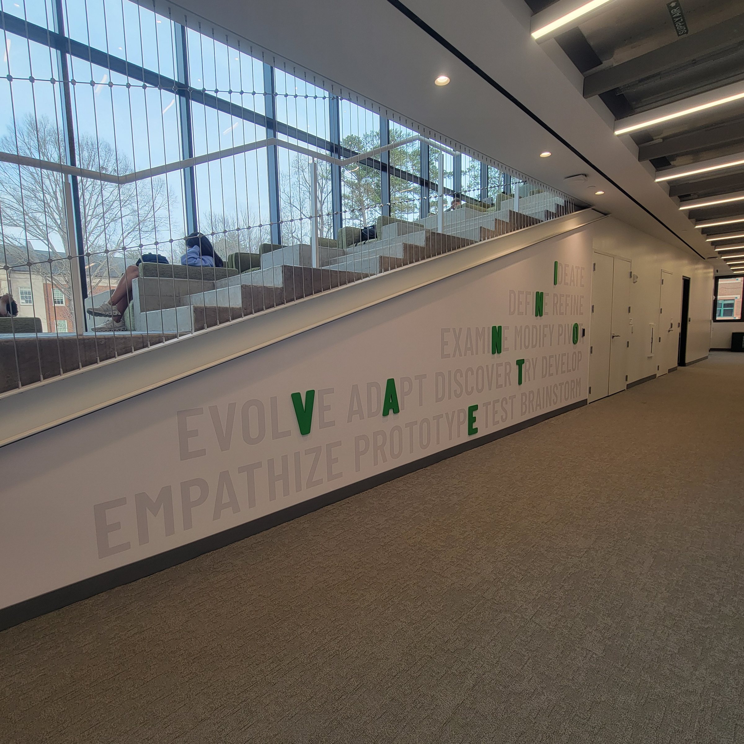 'Evolve / Empathize / Prototype' wall lettering along learning stair, Westminster, by High Stakes Creative
